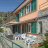 facciata della villa, tenda da sole, tavoli, sedie